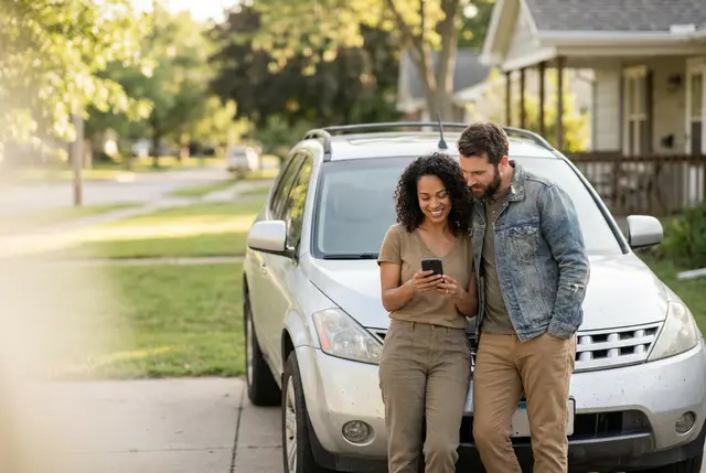 Couple standing by their car